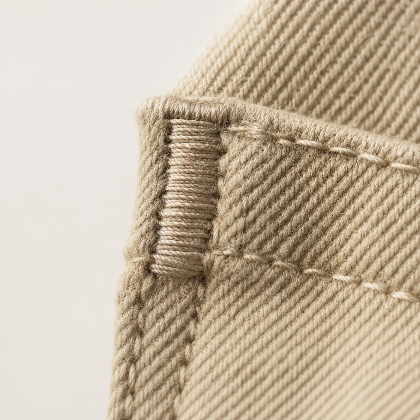 A dense block of stitching reinforcing the corner of a pocket opening.