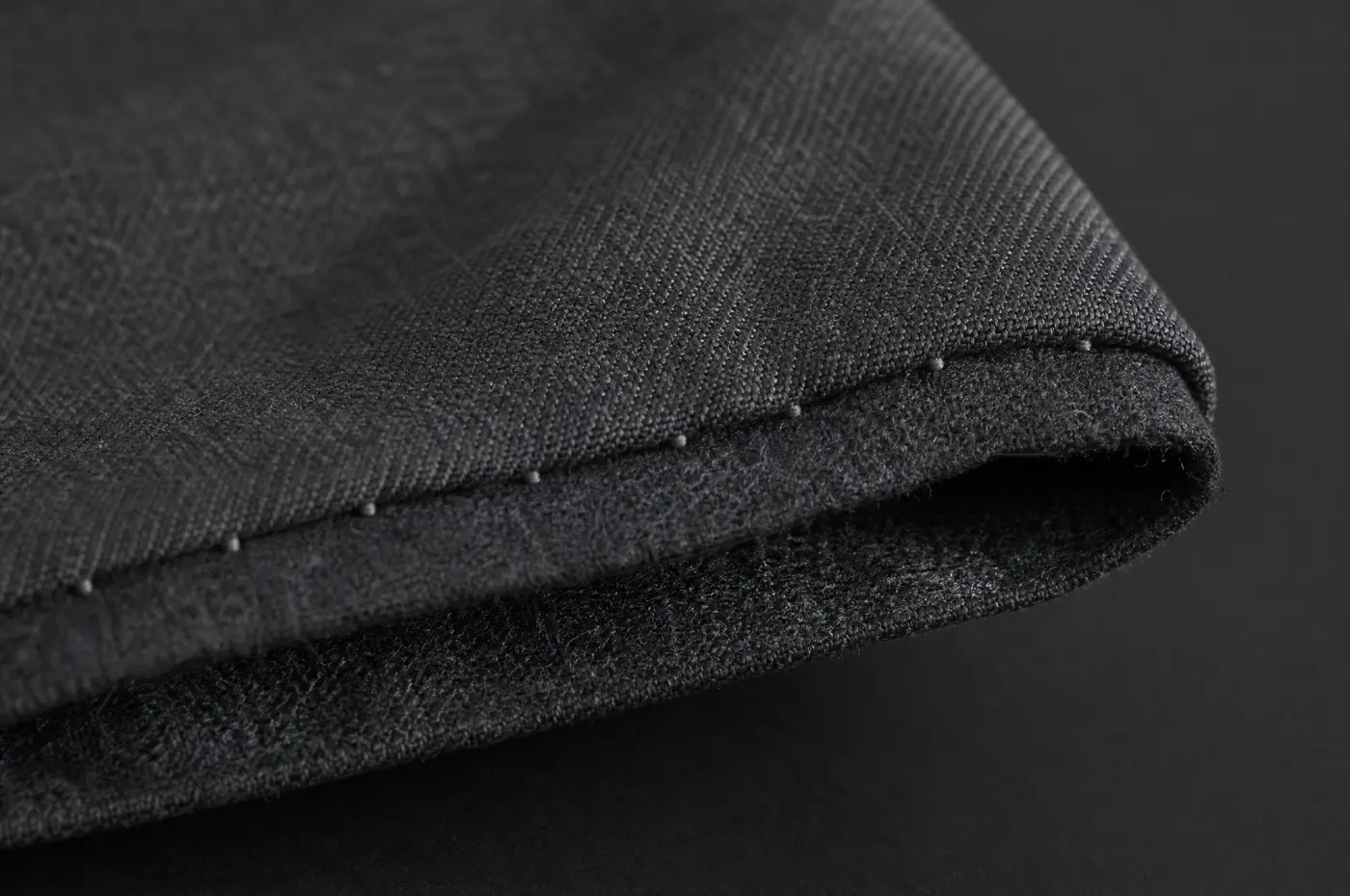 A hem folded back to show a stitch catching only a few fibres of the outer cloth.