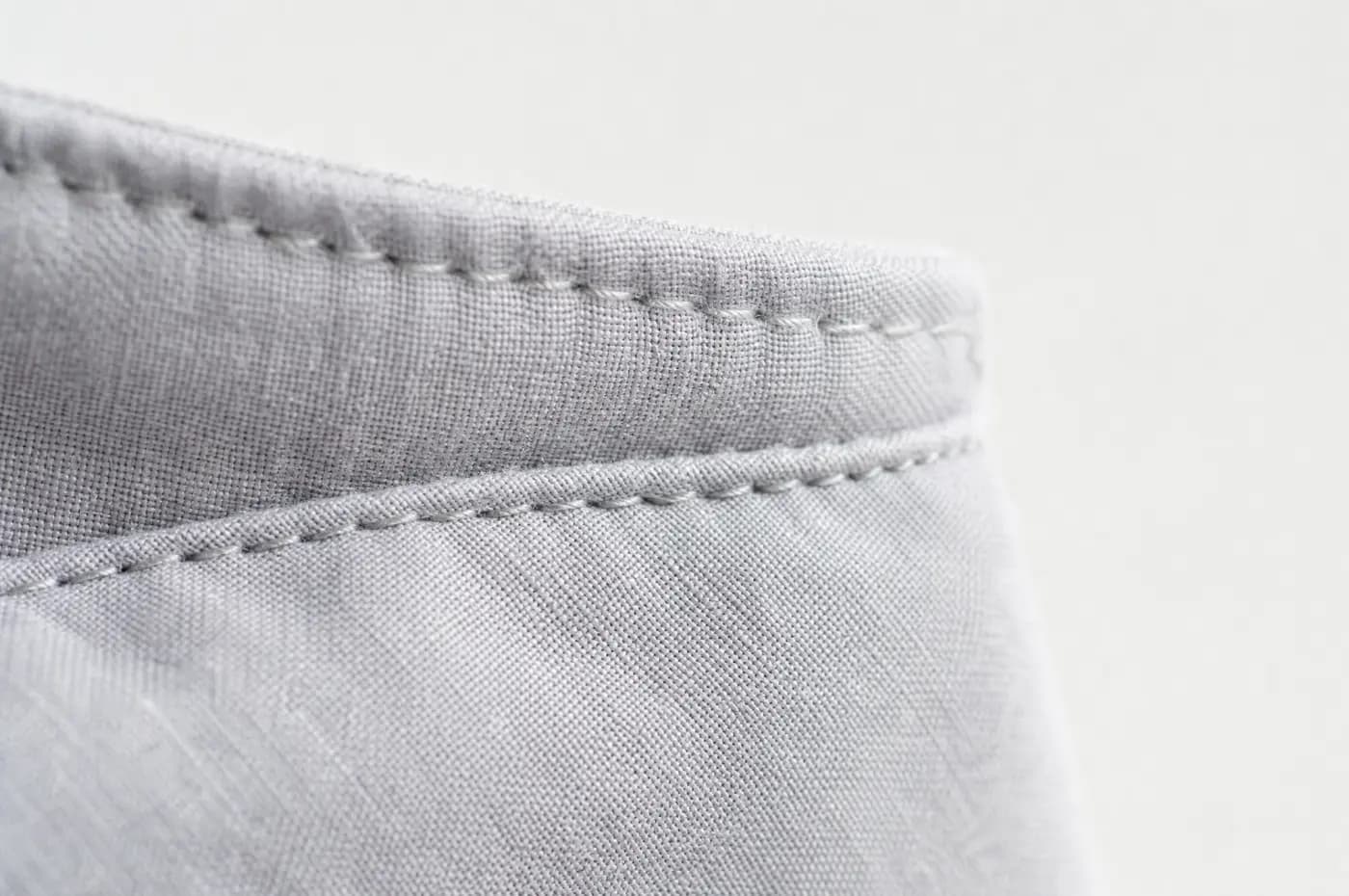 The seam where a shirt collar meets its band, magnified.