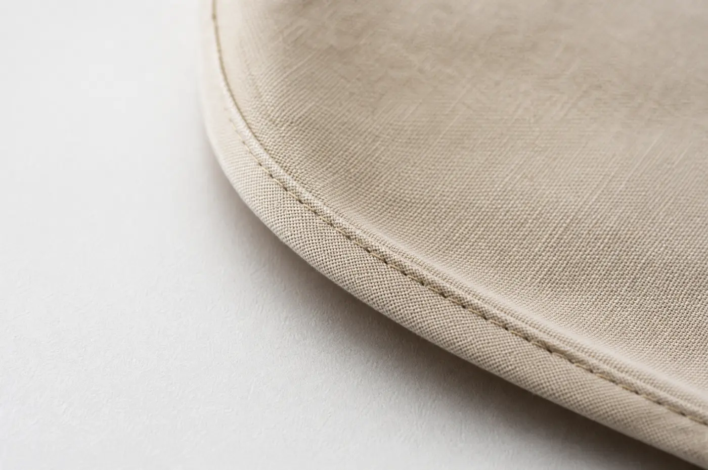 A hem following a curve, the fold narrowing as the curve tightens.