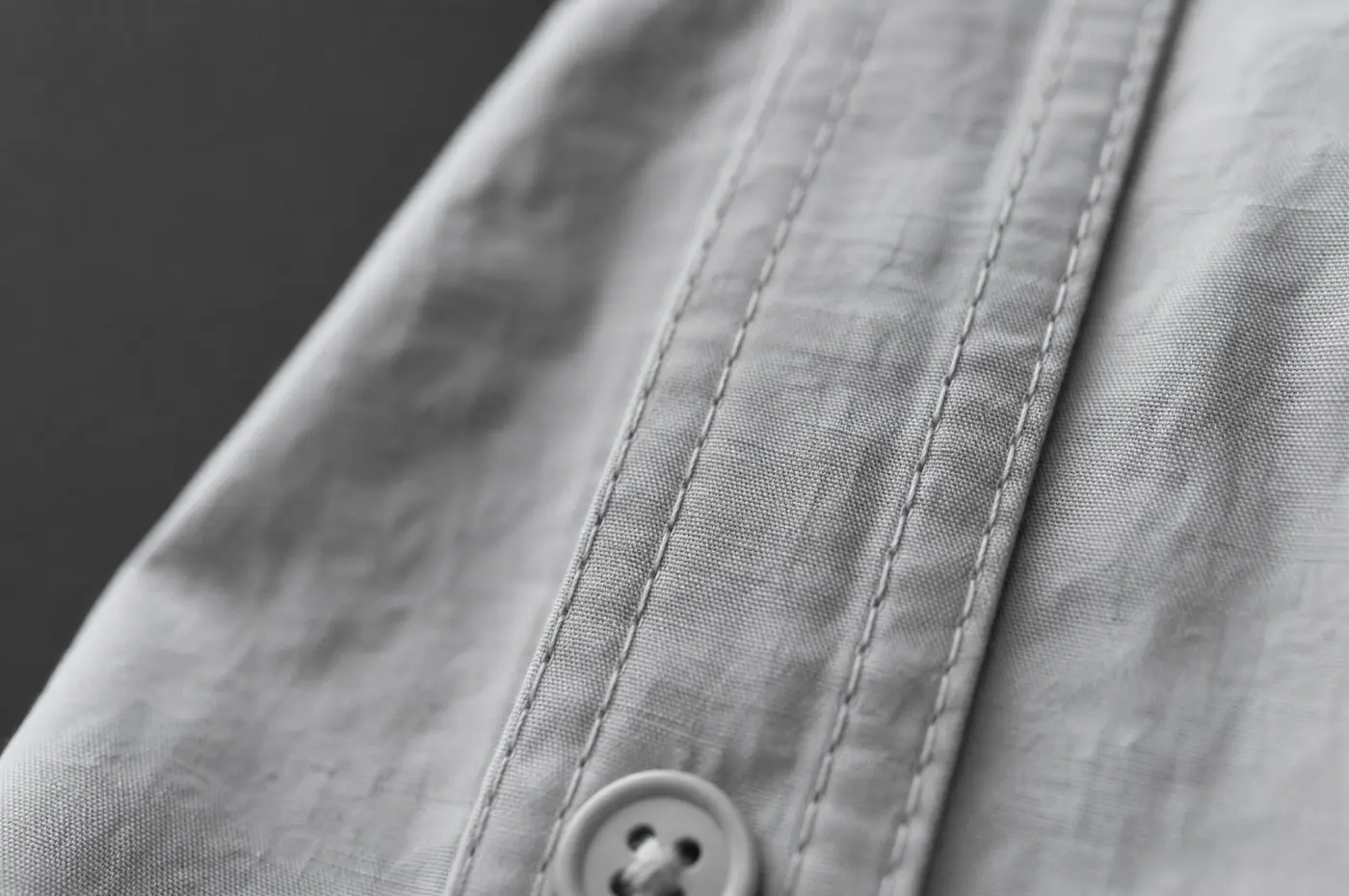 Two rows of stitching running down the folded front placket of a shirt.