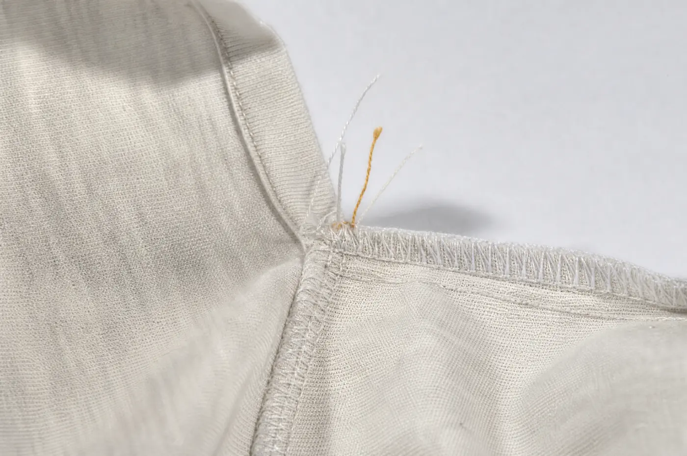 Several short cut thread ends left at a seam intersection inside a garment.